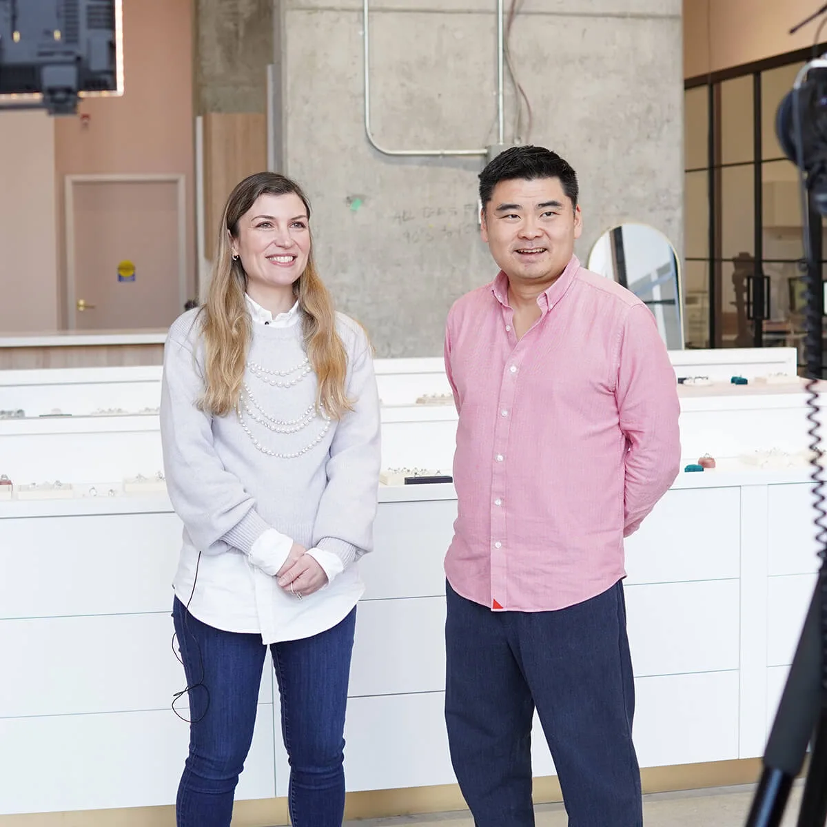 Mariam and Ji Song, Engage Studio's co-founders, standing in the showroom in front of the ring display counters